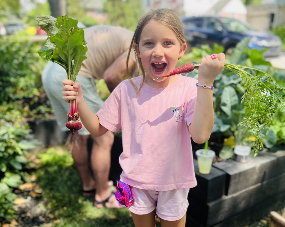 girl holding fresh garden veggies