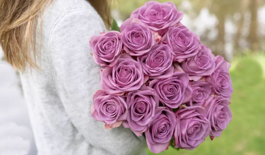 woman holding purple rose bouquet