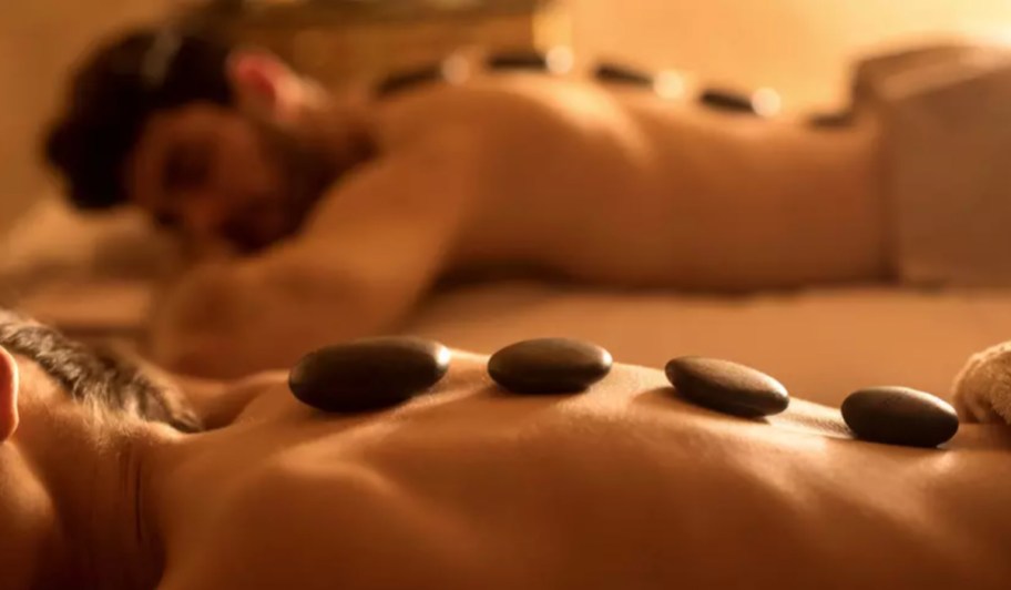 couple getting swedish massage with stones on back