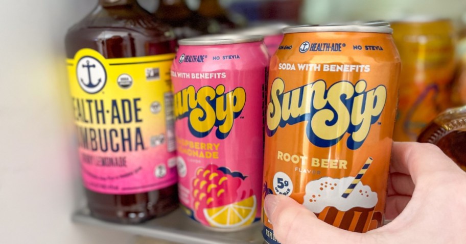hand reaching for a SunSiip Soda in a fridge that has SunSip soda and Health-Ade Kombucha on the shelf