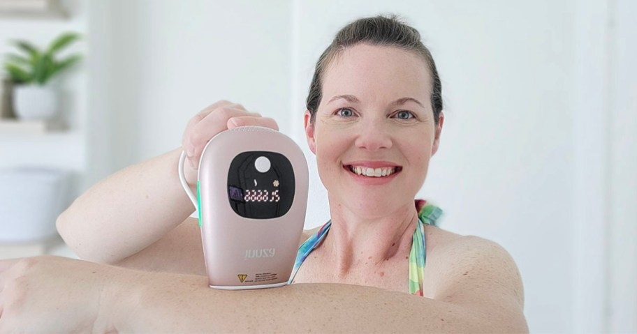 woman using pink hair removal tool on arm