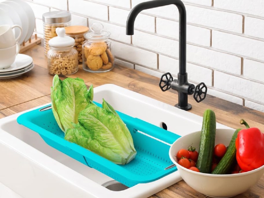 kitchen-with-colander-on-the-sink-with-veggies-next-to-it قابلة للتوسيع فوق مصفاة الحوض مقابل 6.99 دولار فقط على أمازون |  يمكنك شطف الفواكه والخضروات والأرز وغير ذلك الكثير بسهولة