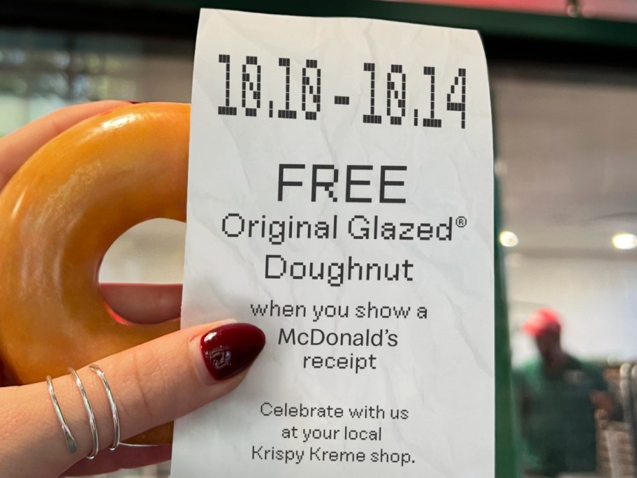 holding a doughnut and a receipt