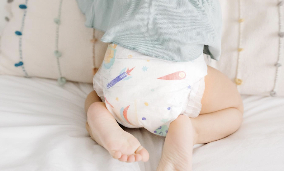 close up of baby in diaper on bed