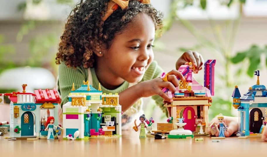 a little girl playing with a disney princess marketplace lego building toy