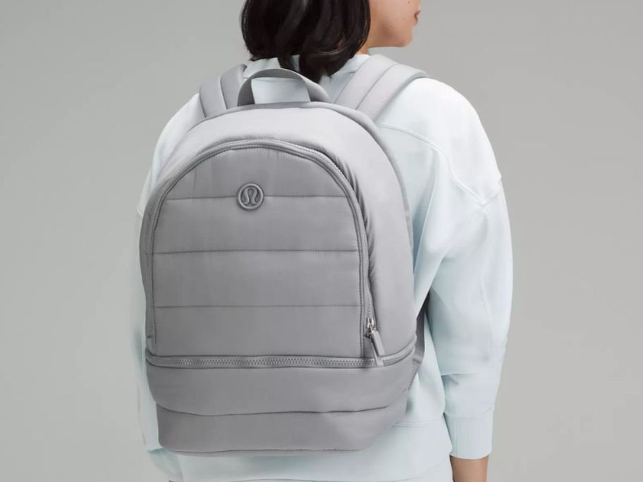Stock image of a woman wearing a lululemon wonderpuff backpack