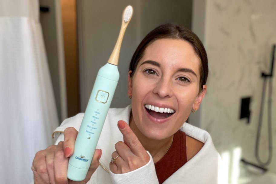 woman holding pointing at electric toothbrush