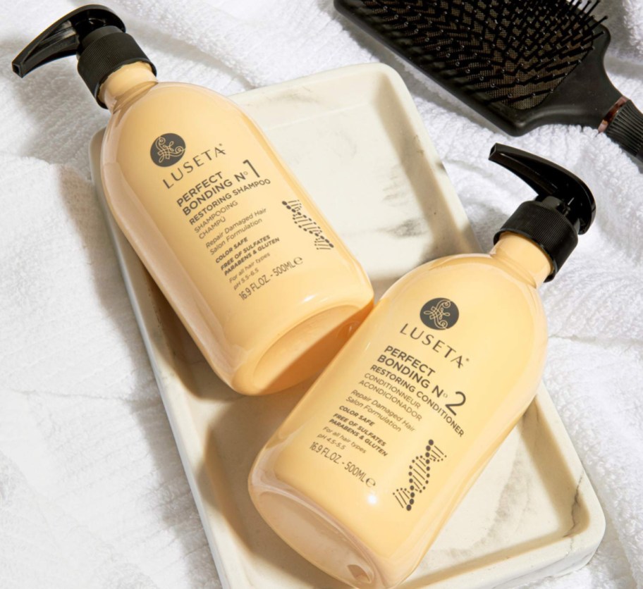 two pale yellow shampoo bottles on white tray
