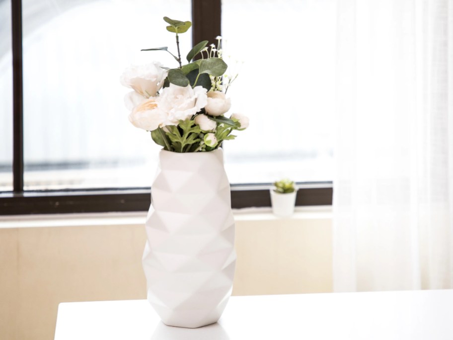 white vase with flowers in it