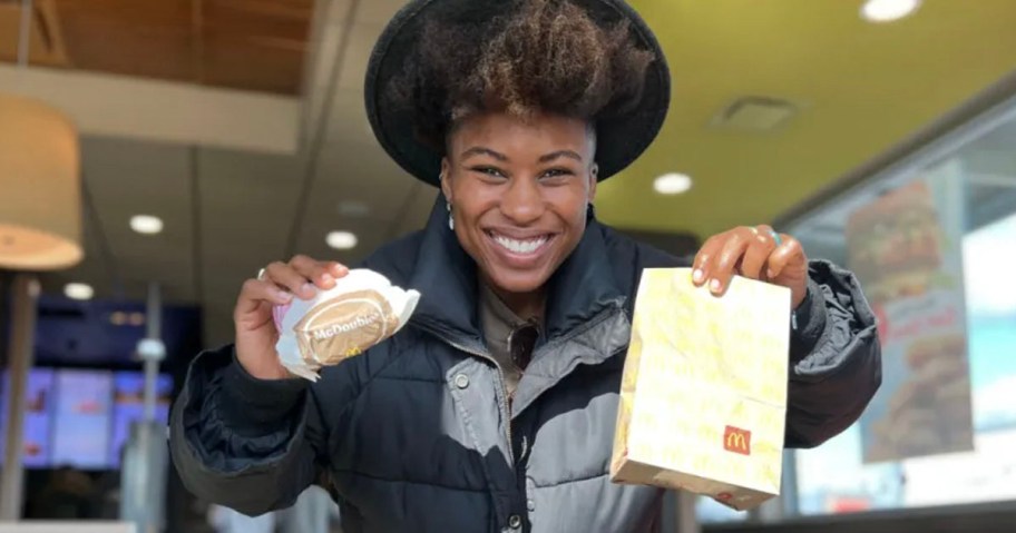 woman holding mcdouble and mcdonalds bag