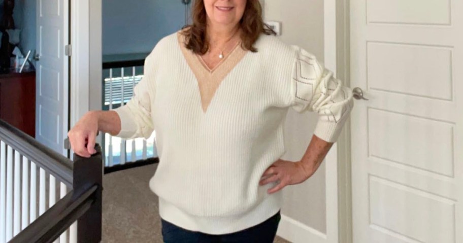 woman wearing cream v neck sweater and jeans
