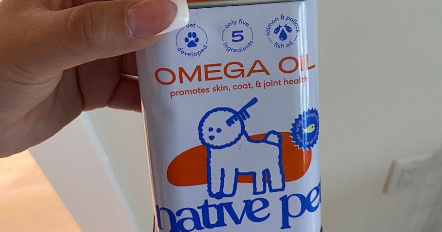 Hand holding a tin of Native Pet Omega Oil