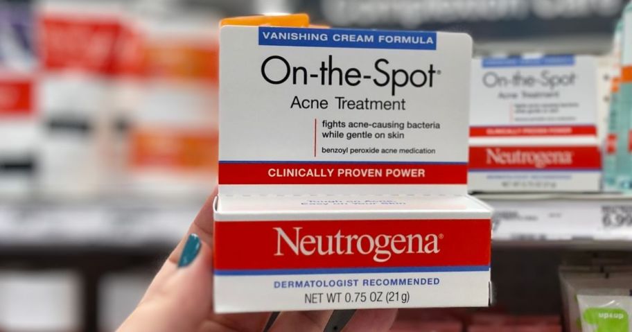 a womans hand holding a box of neutrogena acne treatment