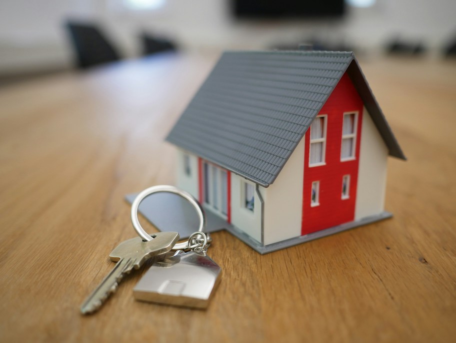 set of keys with toy house on wood table