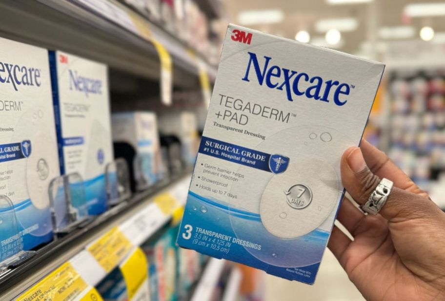 womans hand holding nexcare tegaderm patches
