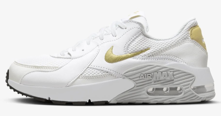 white, grey and gold woman's Nike shoe