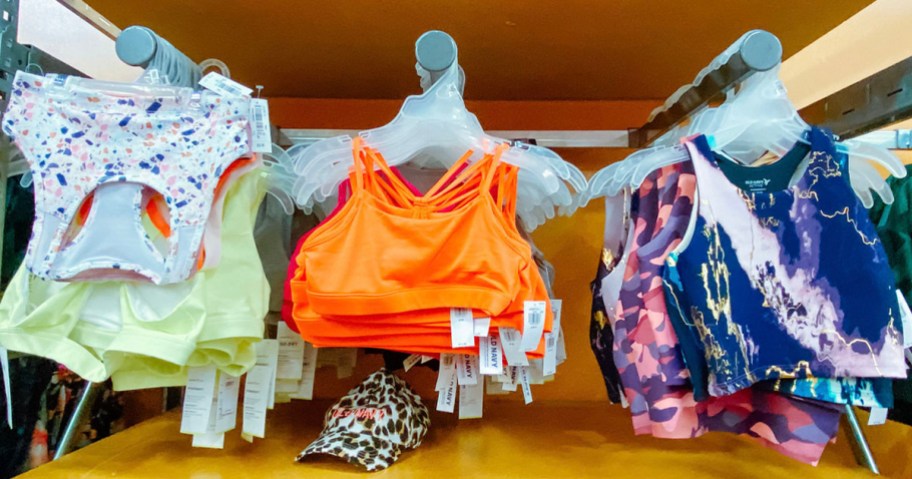 green, orange and blue sports bras hanging in store