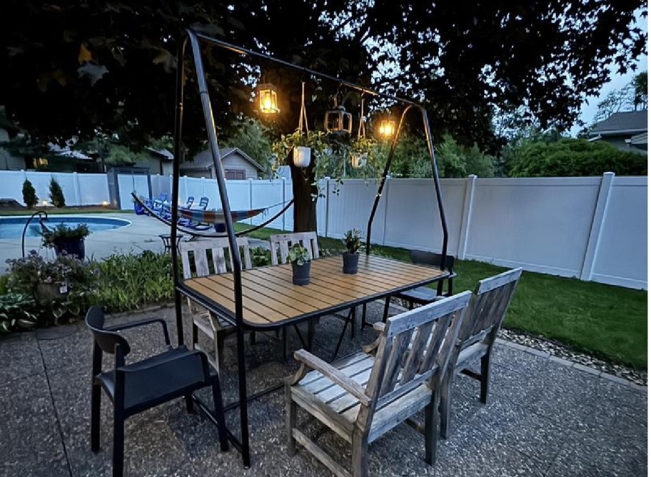 pergola table with lights and plants on it