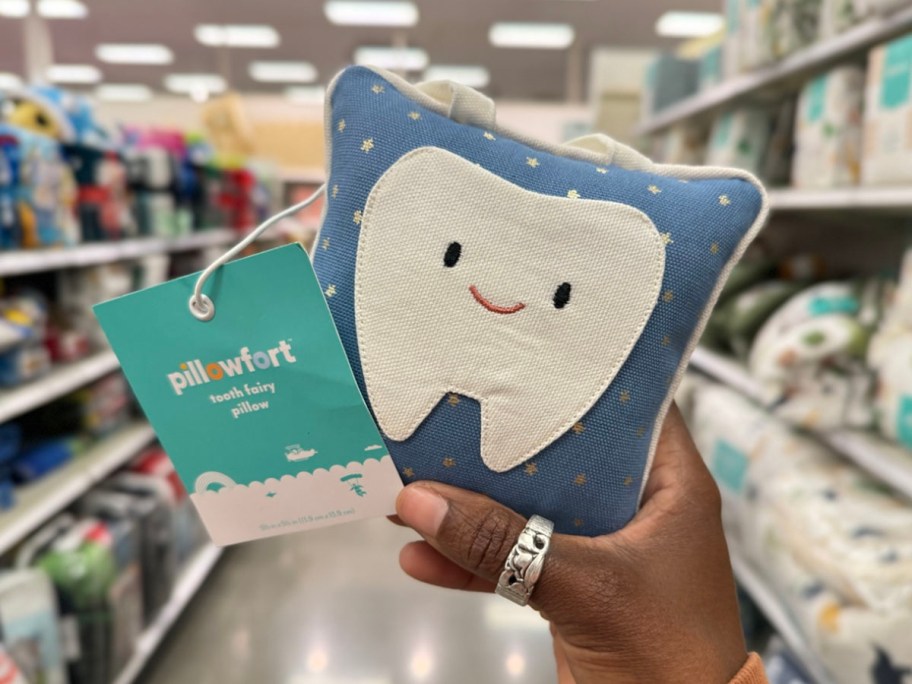 hand holding blue tooth fairy pillow in store