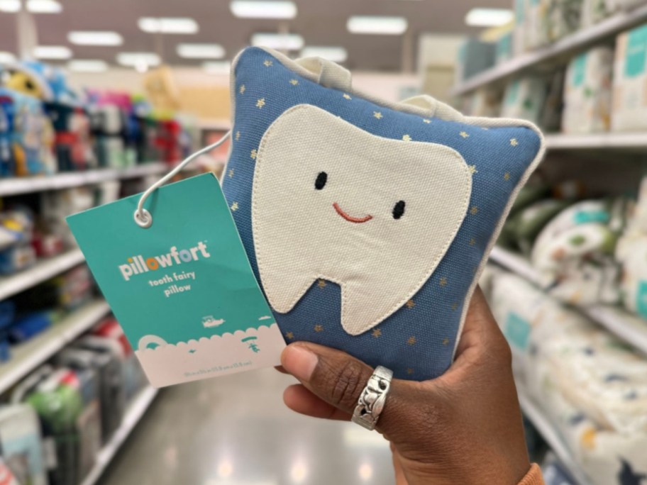 hand holding blue tooth fairy pillow in store