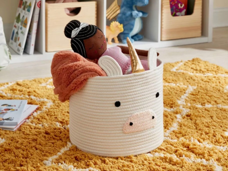 pillowfort unicorn bakset on yellow rug full of toys