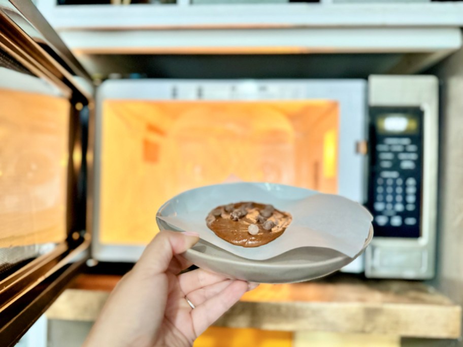 placing one minute protein cookie on a plate in the microwave