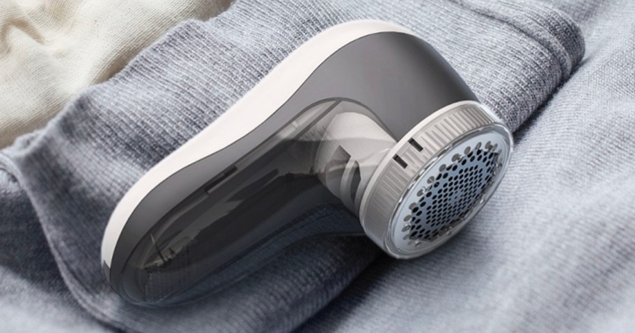 white and gray fabric shaver sitting on blankets