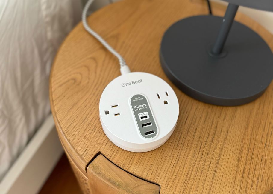 close up of power strip surge protector on wood nightstand
