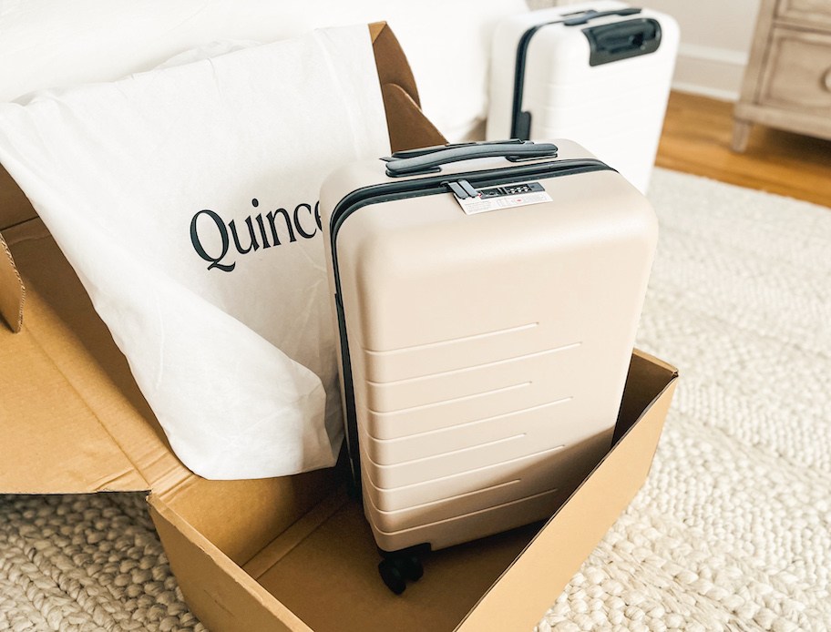 beige carry on luggage with quince dust bag in box