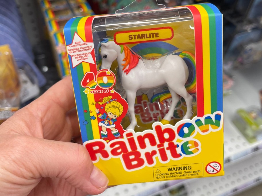 hand holding a box with a Rainbow Brite Starlite Mini Figure in it