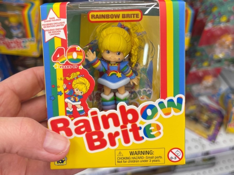 hand holding a box with a Rainbow Brite Mini Doll Figure in it