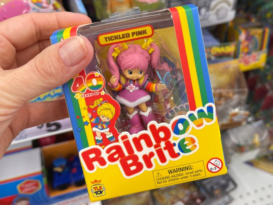 hand holding a box with a Rainbow Brite Tickled Pink Mini Doll Figure in it