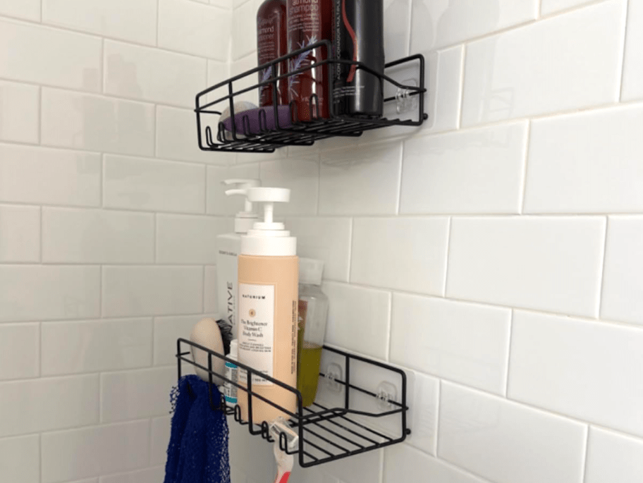 two black shower caddys. hanging in shower with soap in them
