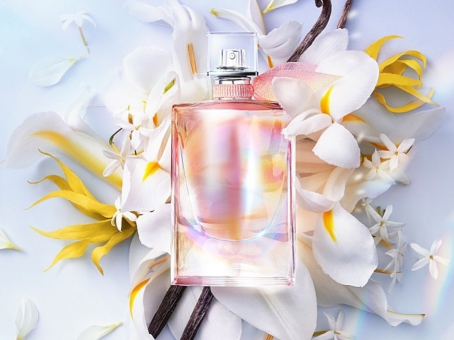 bottle of Lancome La Vie Est Belle Soliel Cristal perfume on top of flowers and vanilla beans