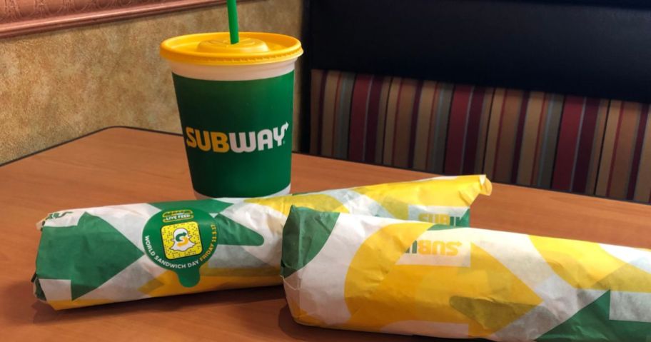 two wrapped subway subs abd a fountain drink