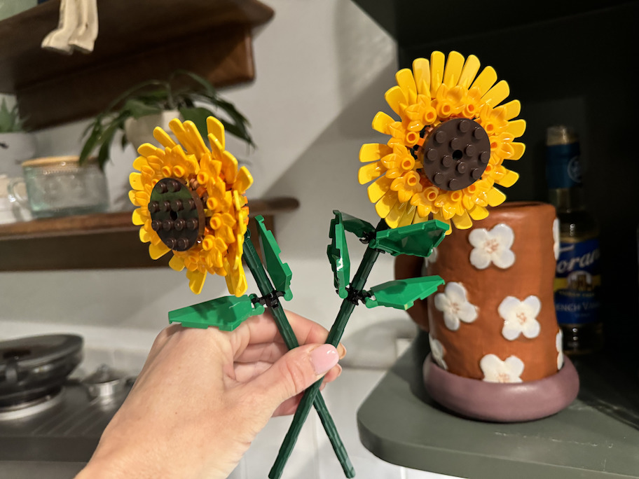 hand holding a pair of lego sunflowers