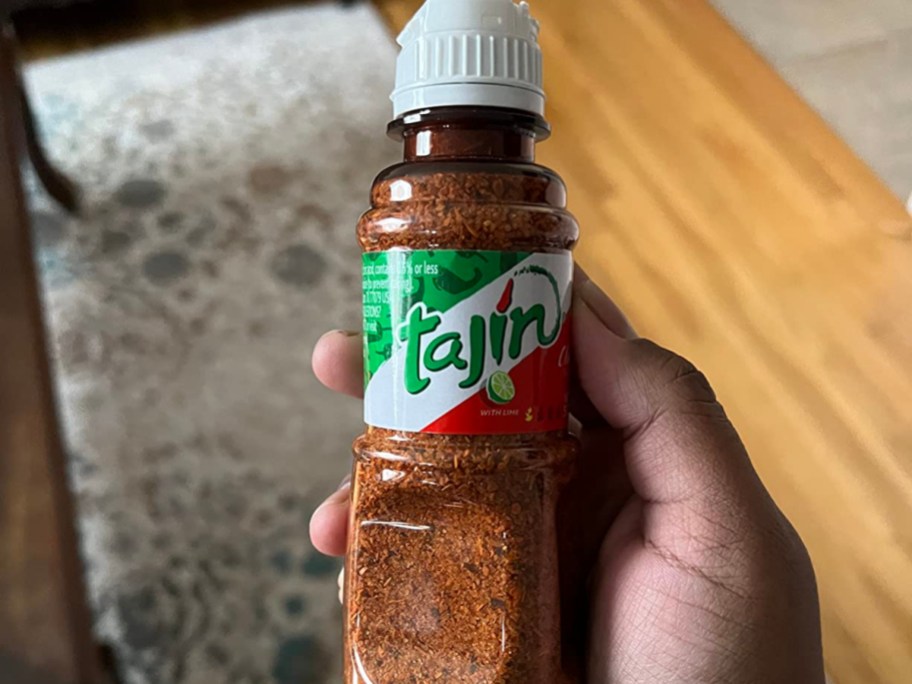 holding a bottle of Tajin seasoning