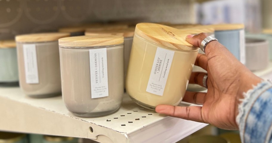 hand taking candle off shelf in target store