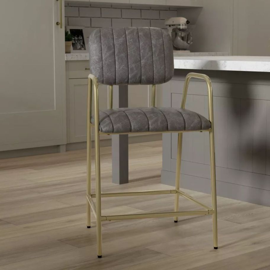 gold bar stool with grey leather seat in a kitchen