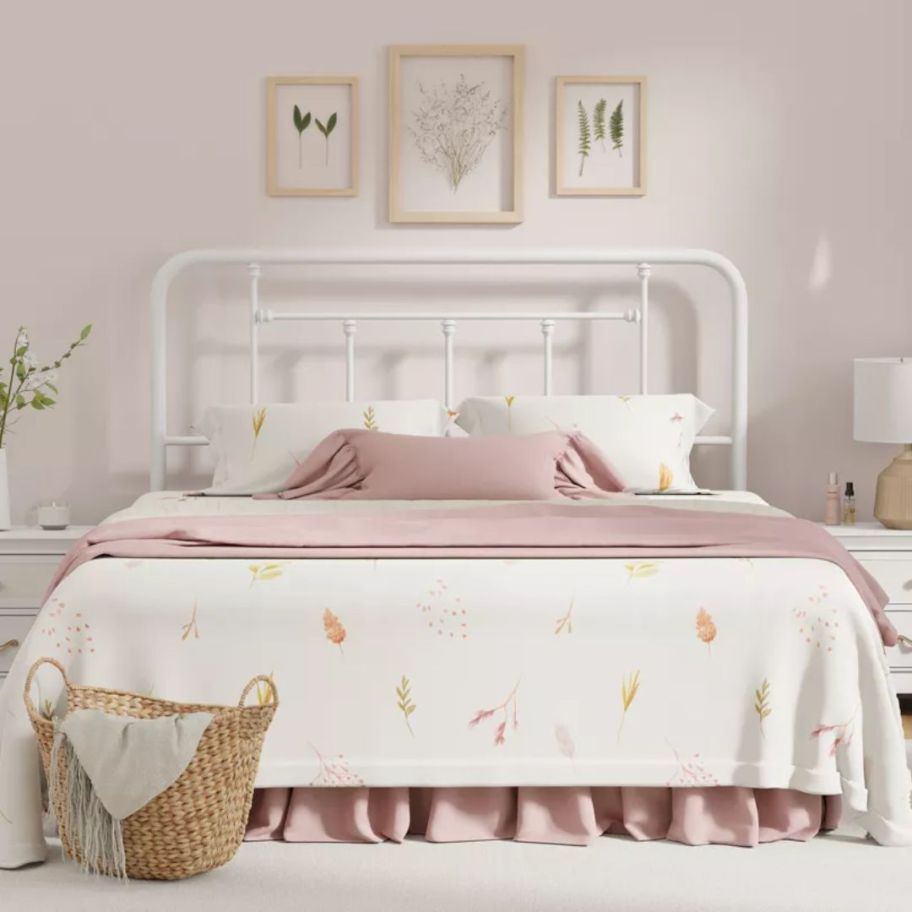 bed with a white metal headboard bed and white and pink bedding