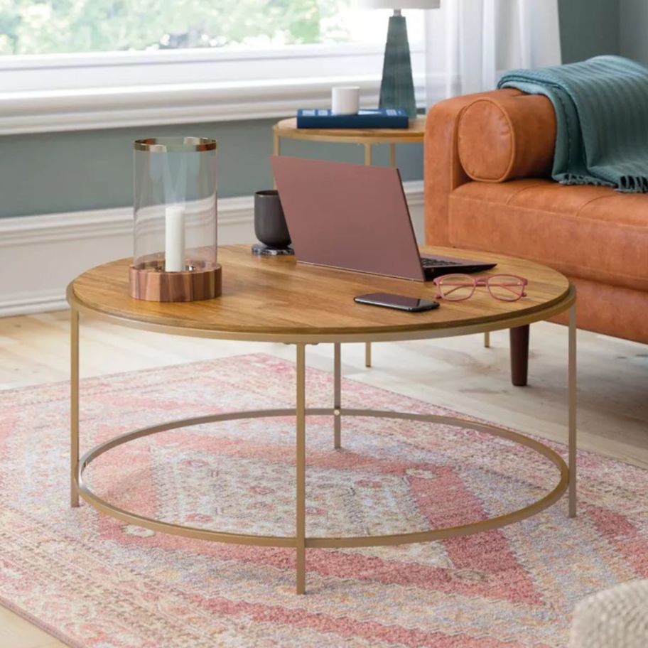 large round wood top and metal base coffee table in a living room