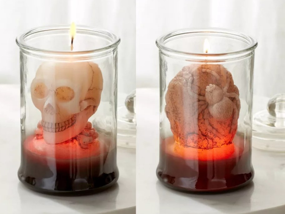 side by side image of 2 glass jar candles 1 with a skull inside and another with a spider inside, lids to the side