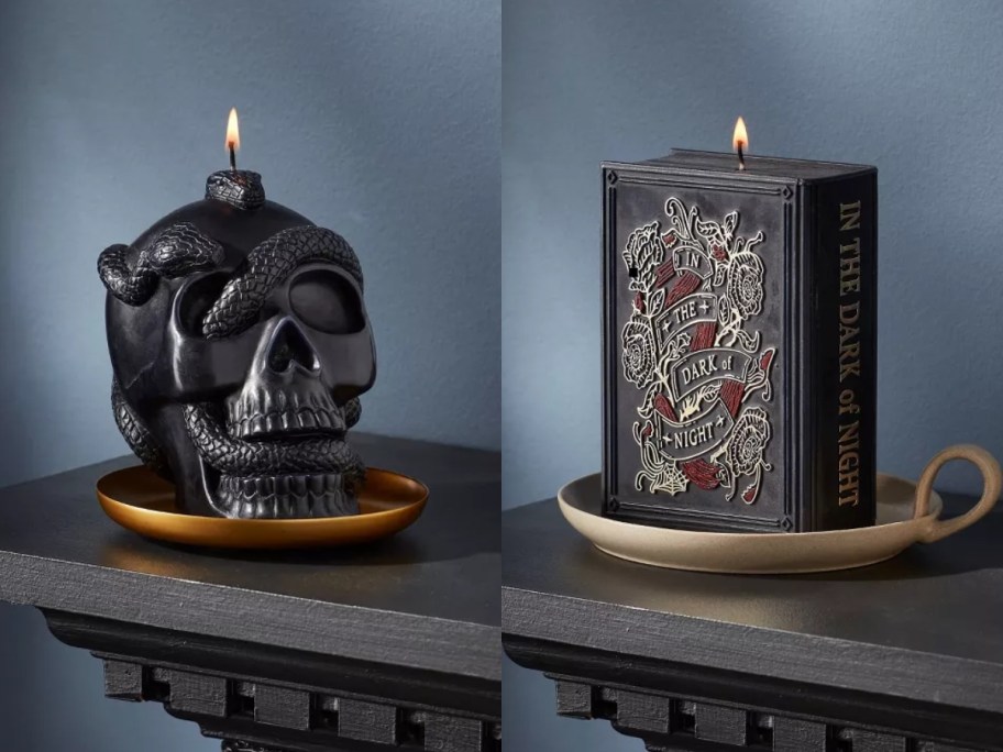 side by side image of a black skull shaped candle with a snake and a black Book of Spells candle both on gold candle plates on black mantles