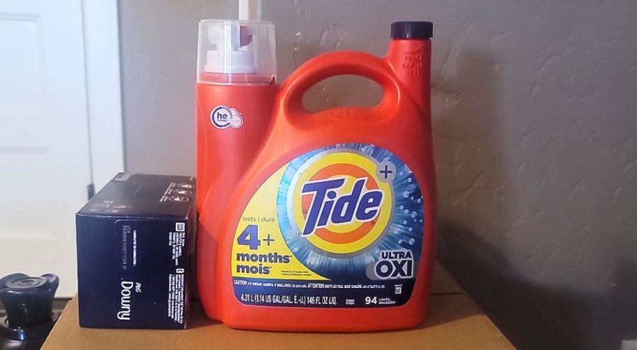 a large jug of tide ultra oxi sitting on top of a large cardboard box