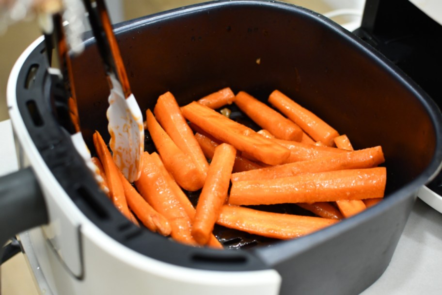 tossing carrots with honey butter inside an air fryer