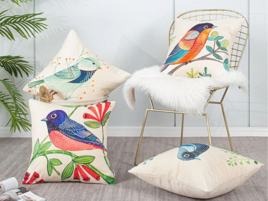 four bird pillows on floor and gold chair