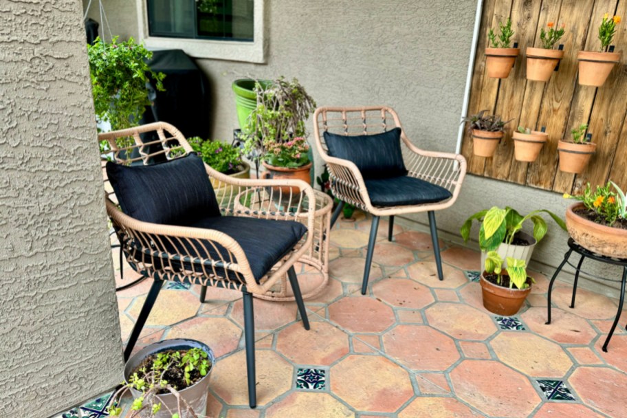 black and wicker outdoor patio set displayed outside near flowers