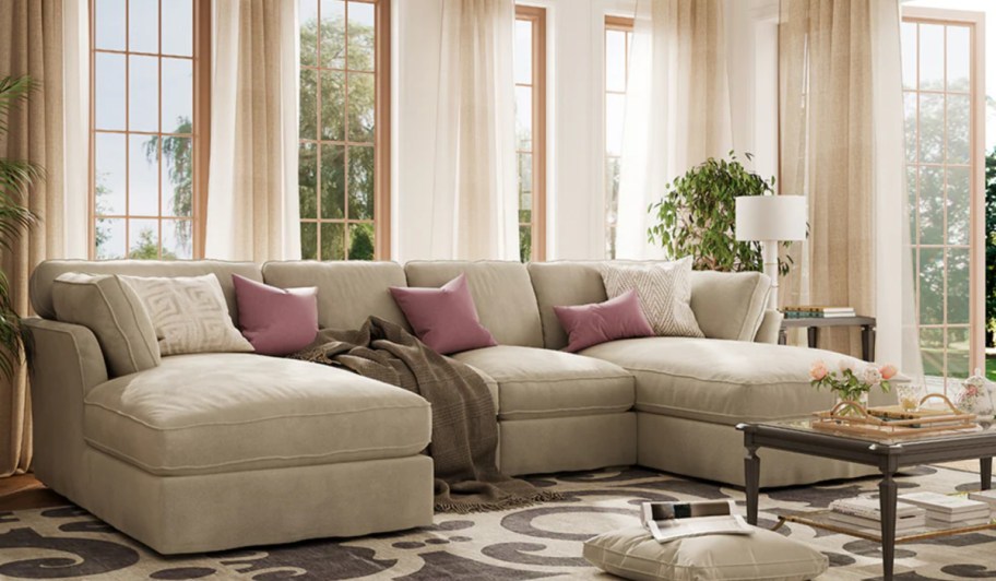 cream sectional in living room with curtains