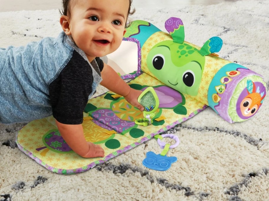 baby laying on a tummy time mat with toys