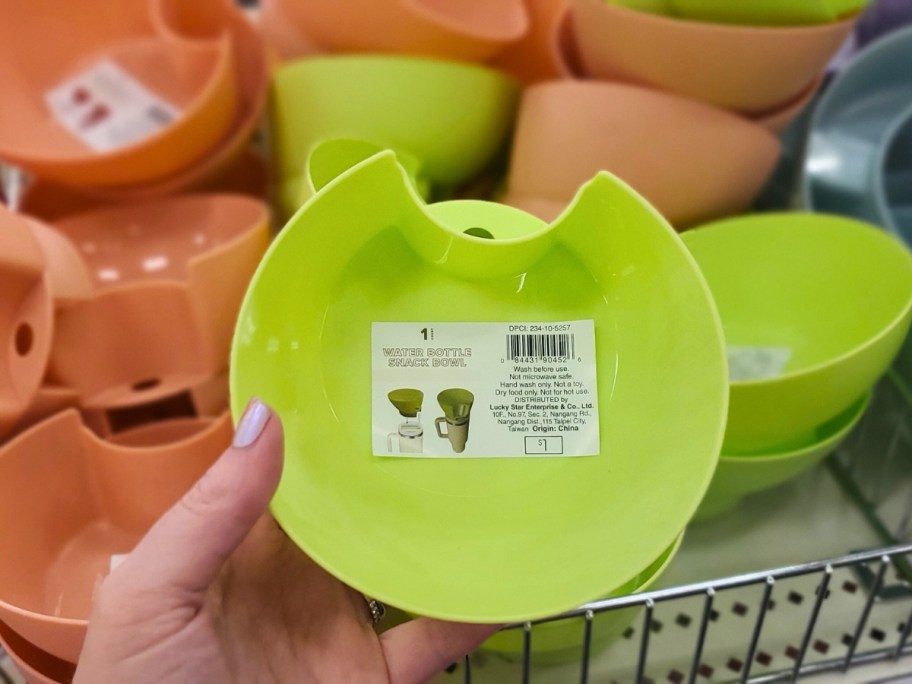 hand holding a lime green Tumbler Snack Bowl Accessory in store with more in the background
